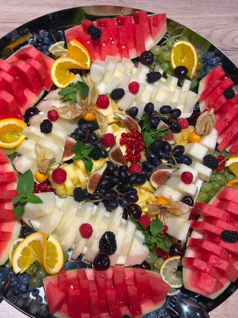 Runde Obstplatte mit Wassermelone, Feigen, Beeren, Trauben und Minze