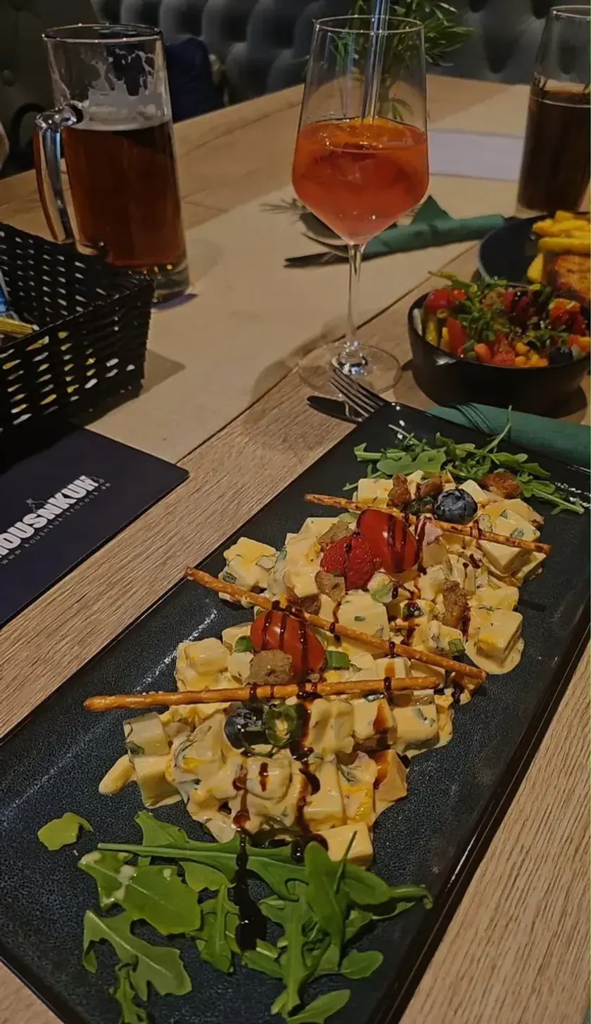 Gedeckter Tisch mit Bier, Aperitif und einer Vorspeisenplatte