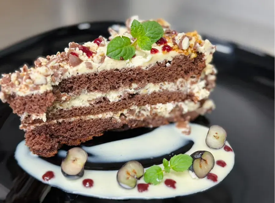 Stück Schokoladentorte mit Beeren und Minze